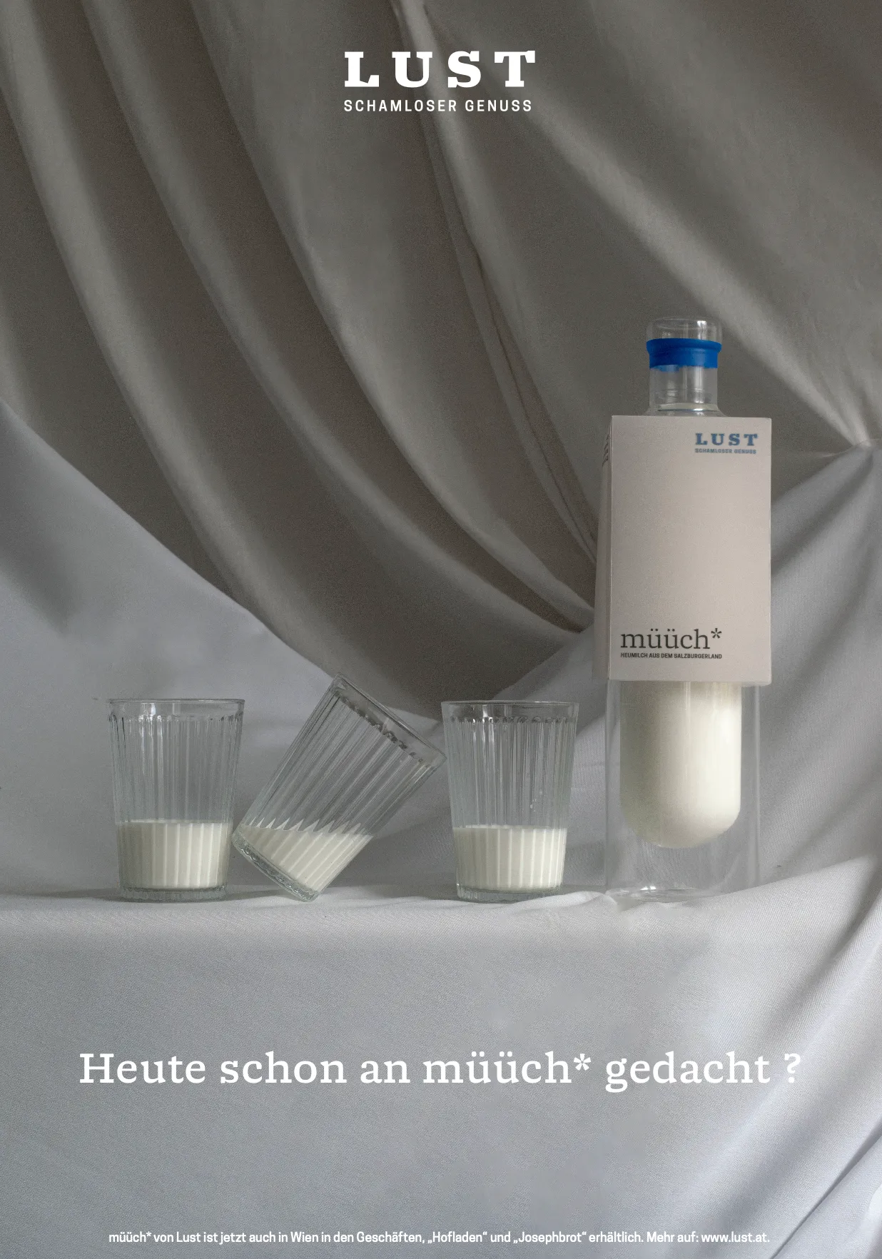 Produktplakat mit inszenierter Milchflasche und Gläsern vor Stoffkulisse